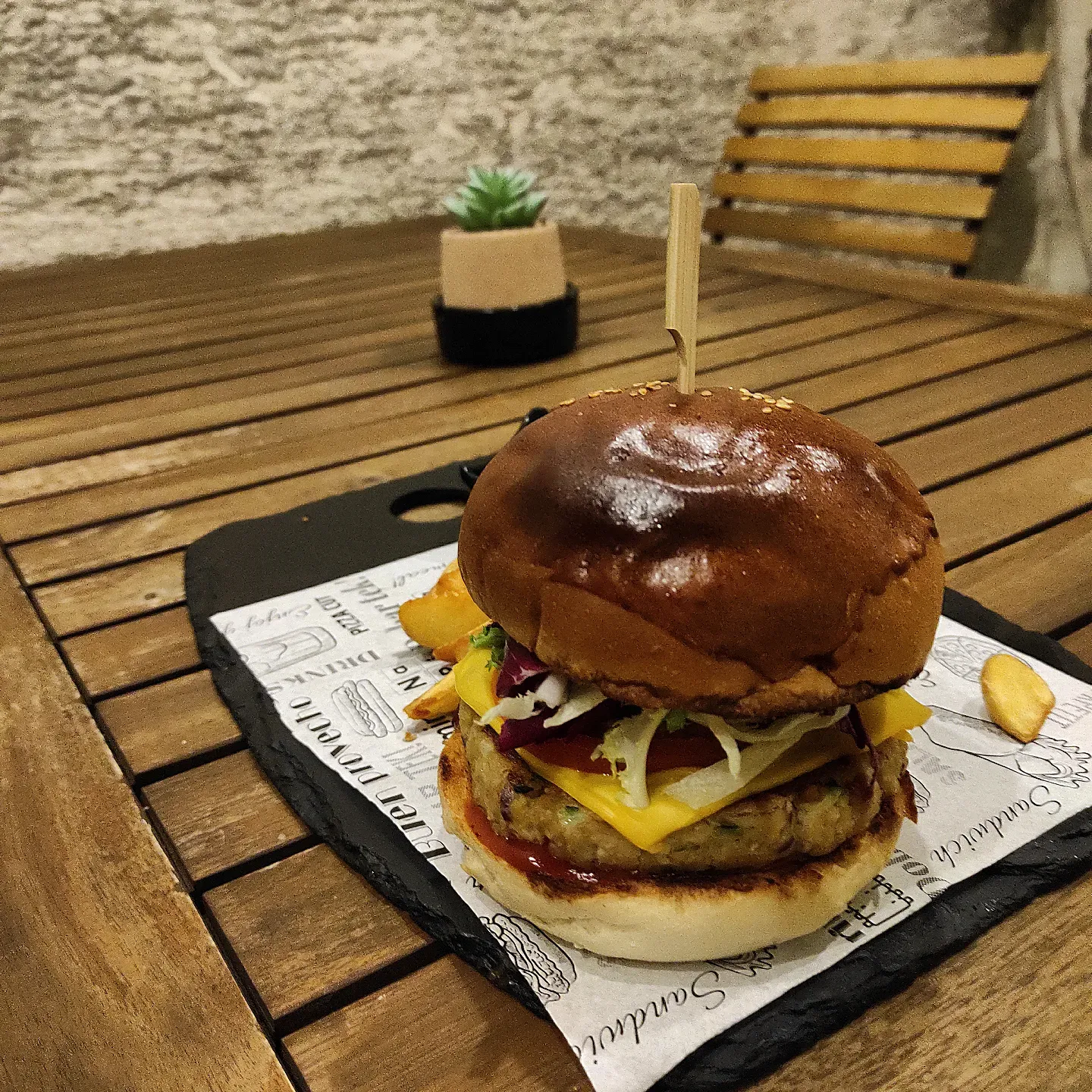 Vege burger s dodatkom cheddara na tamnoj dasci